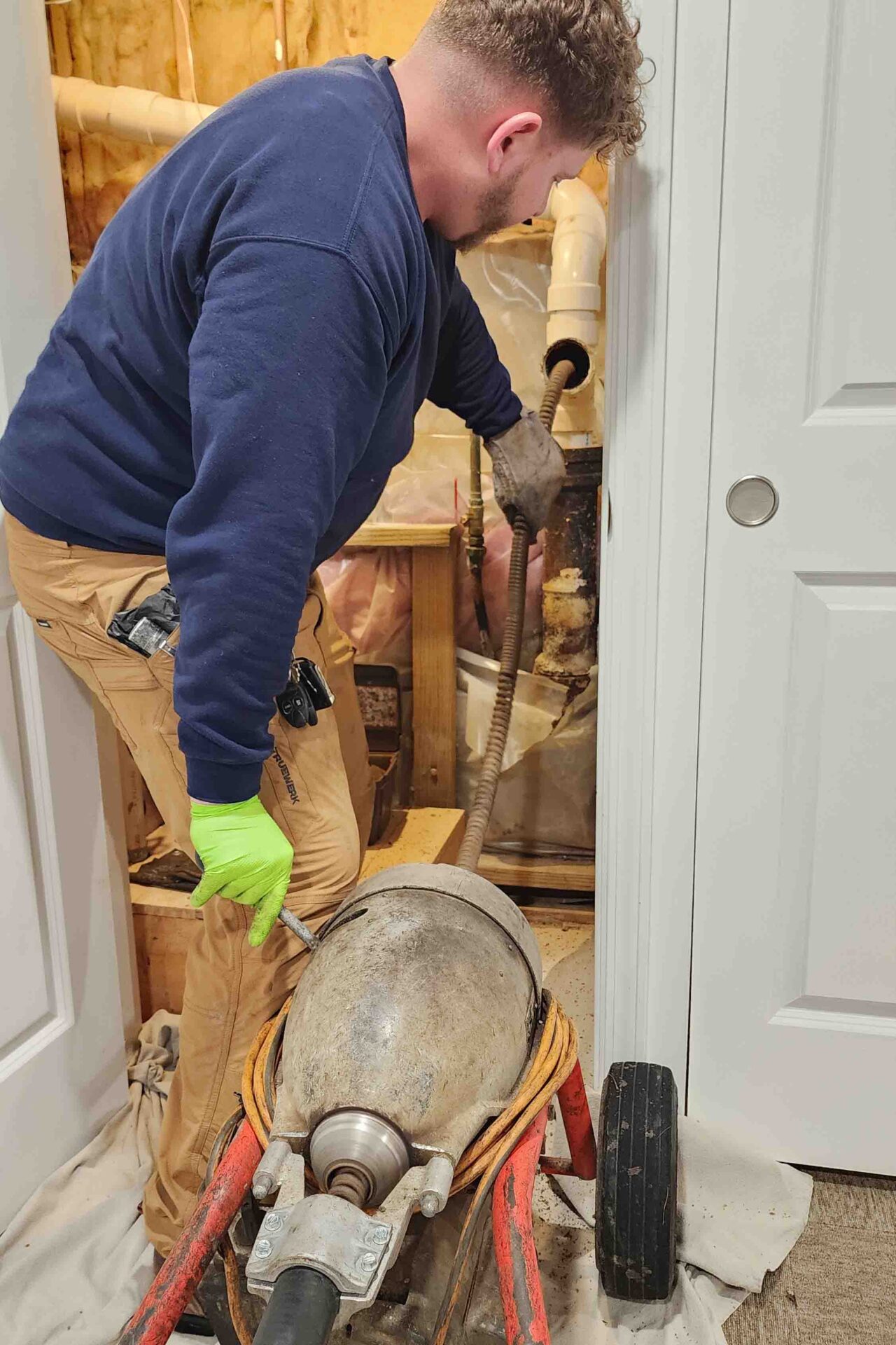 drain cleaning service technician clearing clogged pipe