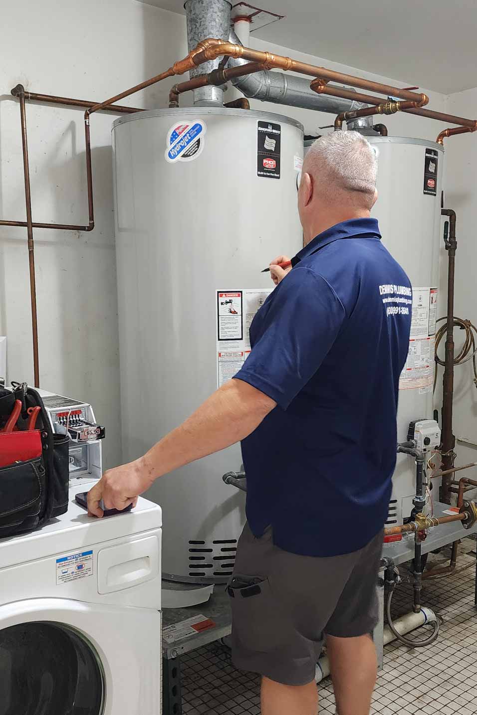 Water heater repair near me technician inspecting leaking tank